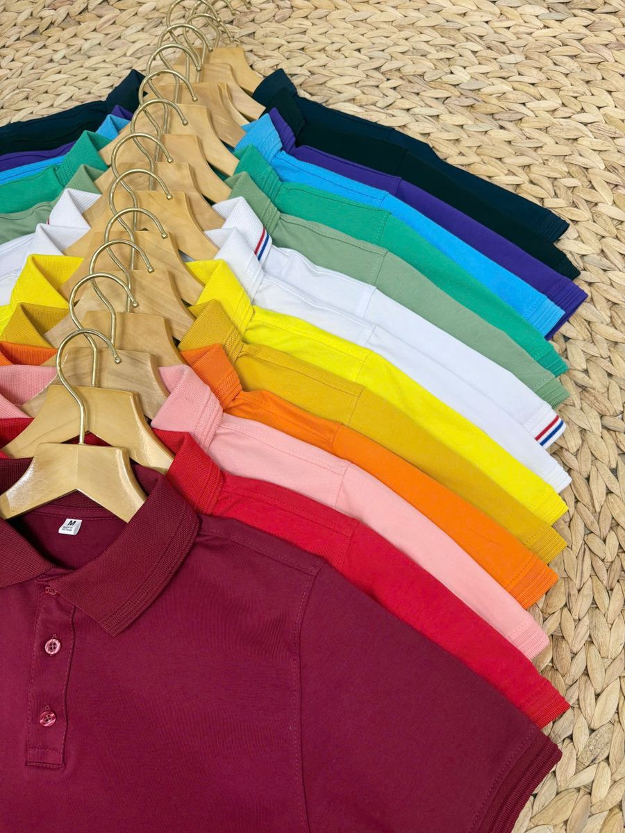 Stapel polo-shirts in verschillende kleuren, waaiervormig uitgelegd
